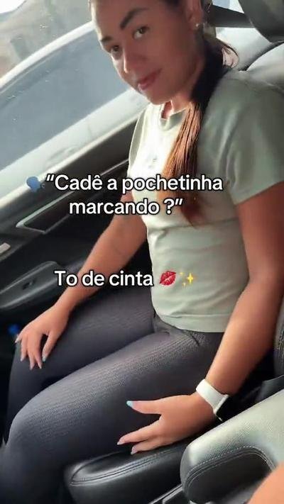 Cliente a mostrar o caimento da peça por baixo da t-shirt, no carro.